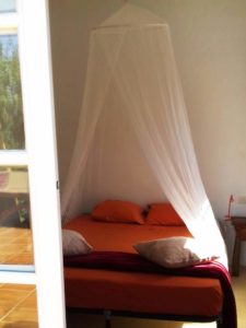 Casita ventana de la habitación, cama con mosquitera