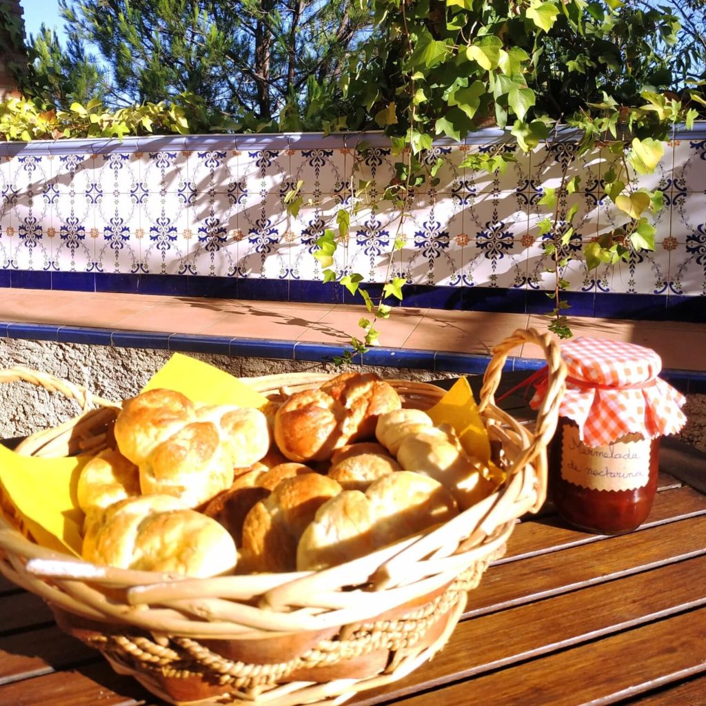 table avec petit déjeuner pour deux personnes sur une terrasse avec carreaux de faïence