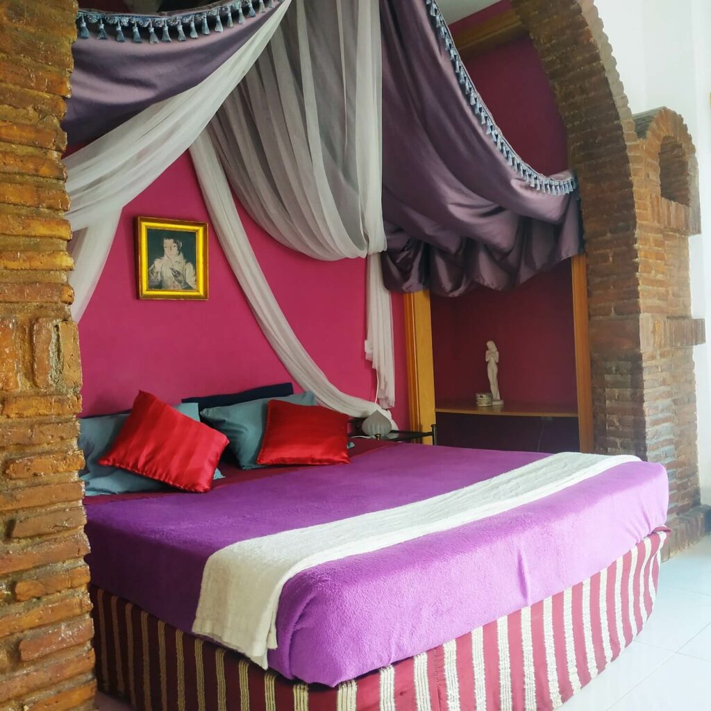 Bed in alcove with hangings, side view