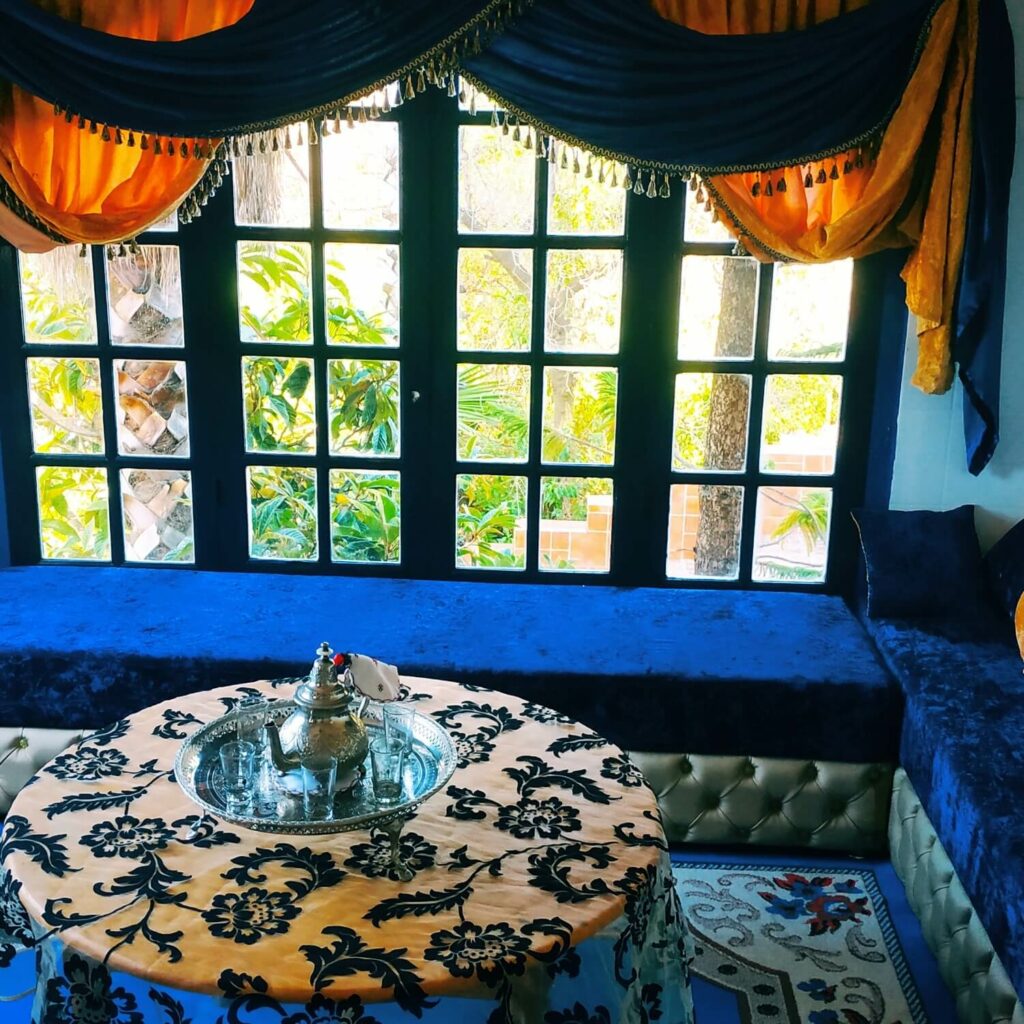 Arabisches Wohnzimmer mit einem Fenster, durch die Scheibe sieht man Palmen